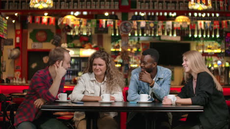 Fröhliche-Multiethnische-Gruppe-Von-Freunden-In-Einem-Restaurant,-Die-Kaffee-Trinken,-Reden-Und-Diskutieren,-Geschichten-über-Die-Universität-Erzählen-Und-Sich-An-Lustige-Momente-Erinnern.
